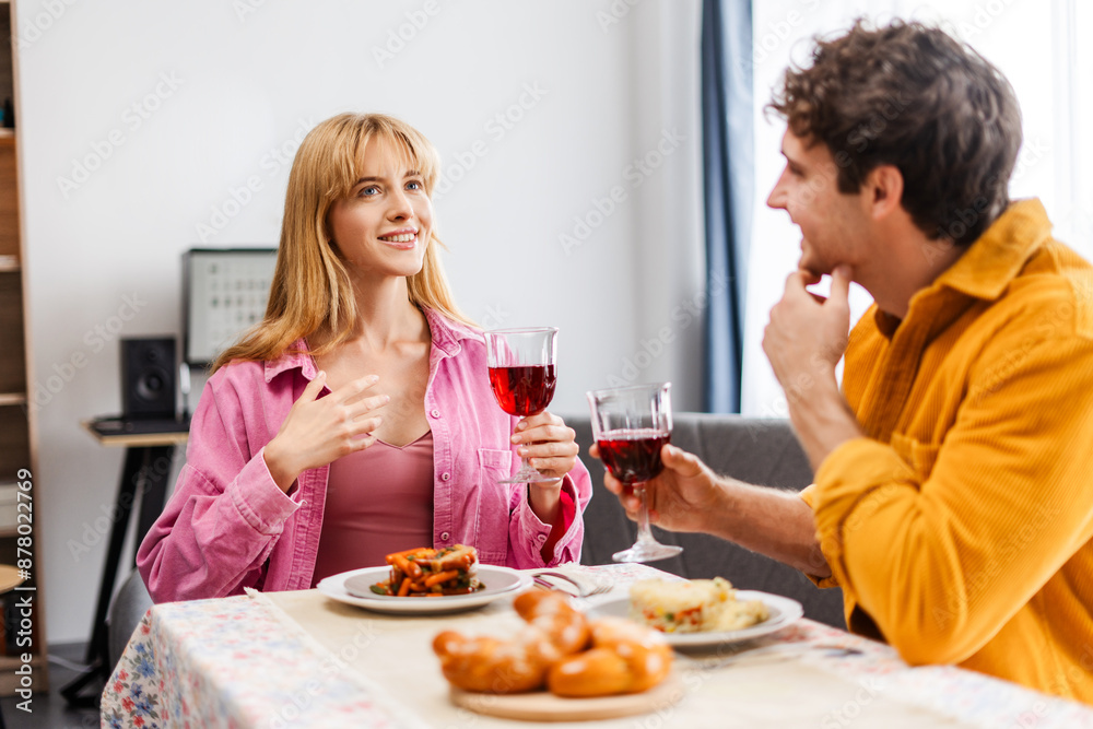 Young couple enjoying delicious food and wine while having lunch together at home Young couple enjoying delicious food and wine while having lunch together at home