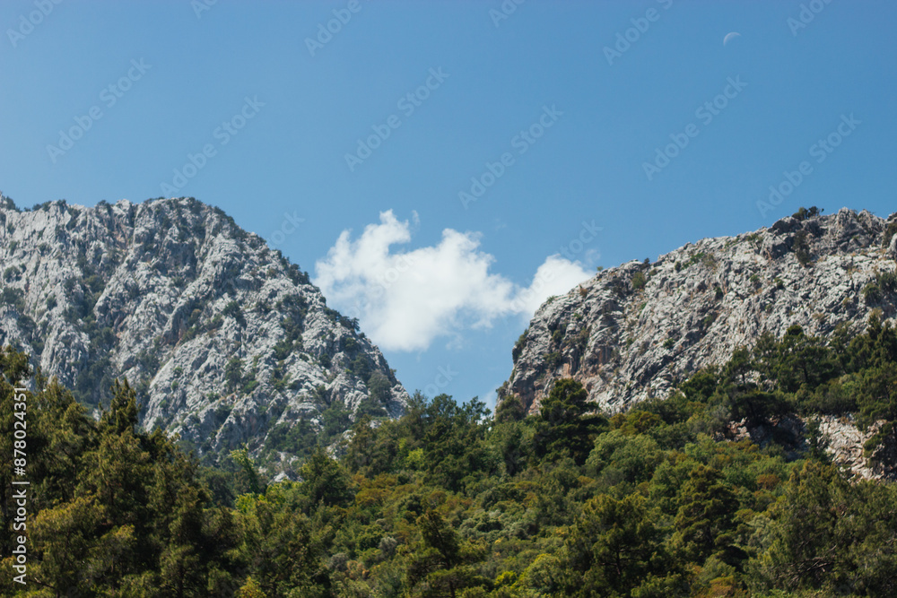 two mountains form a natural frame in the middle of which is a white cloud against the background of the blue sky two mountains form a natural frame in the middle of which is a white cloud against the background of the blue sky