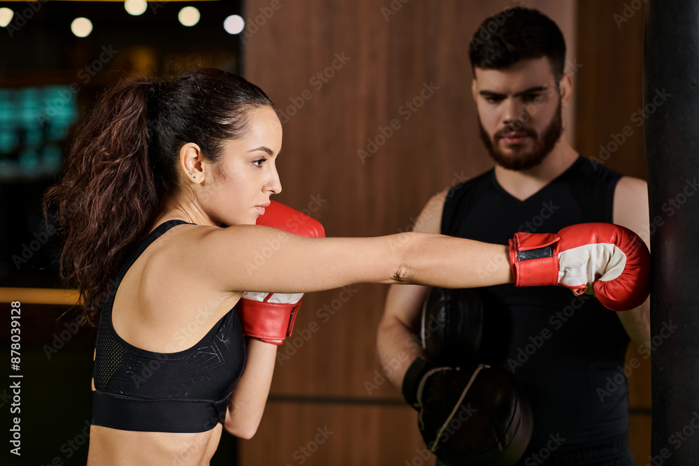 A male trainer cheers on a brunette sportswoman as they spar in a boxing ring at the gym. A male trainer cheers on a brunette sportswoman as they spar in a boxing ring at the gym.