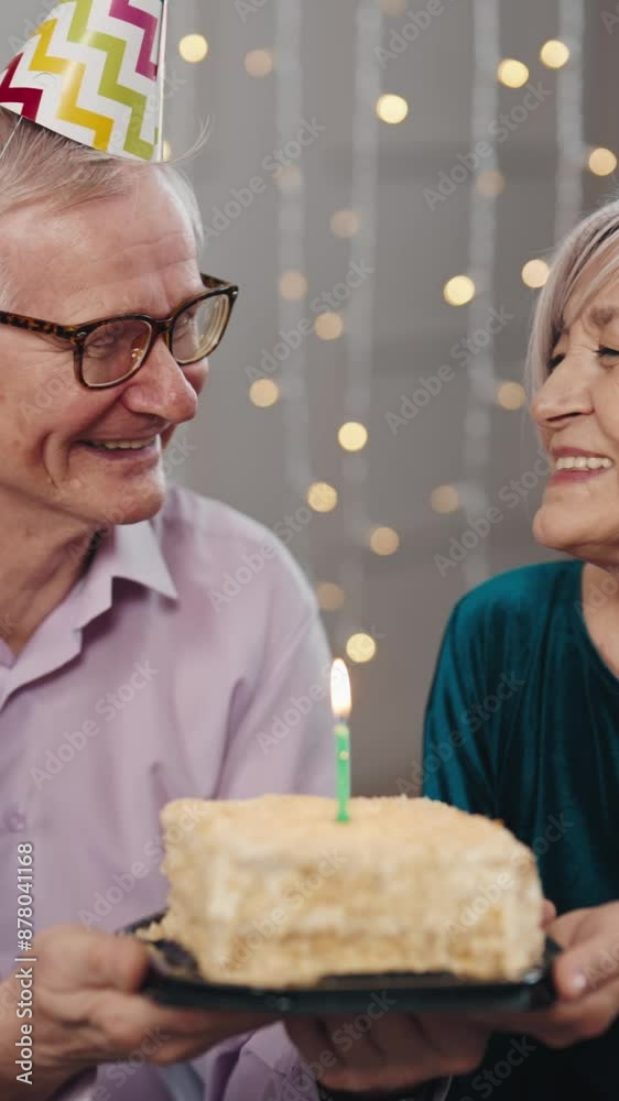 Old married couple celebrating anniversary or birthday, senior man and woman holding cake with one candle. Happy marriage, cheerful grandfather and grandmother smiling and laughing, together forever Old married couple celebrating anniversary or birthday, senior man and woman holding cake with one candle. Happy marriage, cheerful grandfather and grandmother smiling and laughing, together forever