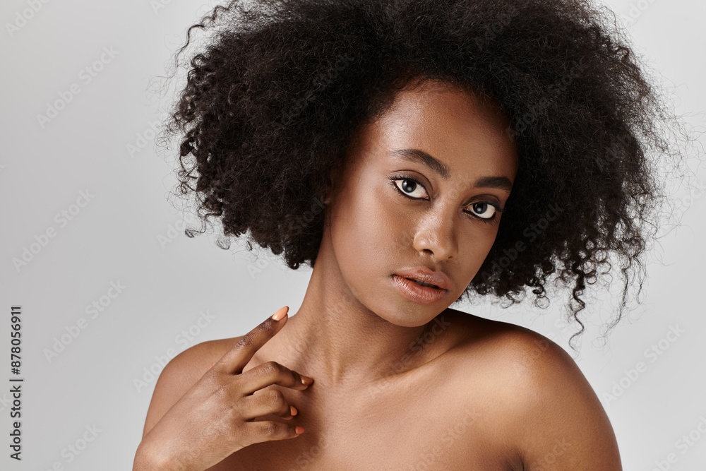 A stunning African American woman with curly hair in a studio, striking a pose for a portrait. A stunning African American woman with curly hair in a studio, striking a pose for a portrait.
