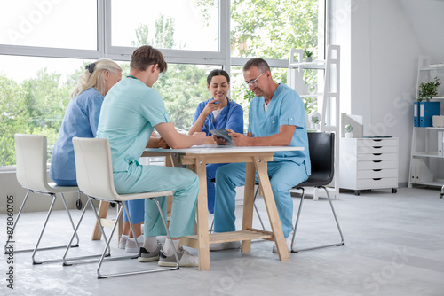 Group of doctors studying x-ray image at table in clinic