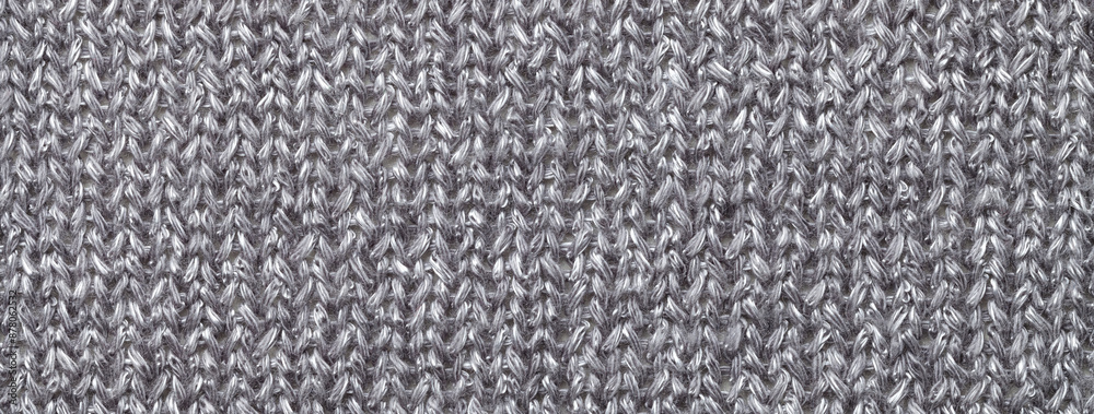 Fototapeta premium Texture of gray color background from woven knitted textile material with wicker pattern, macro.