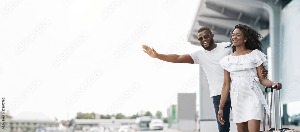 Black couple is standing outside an airport terminal, waving goodbye as ...