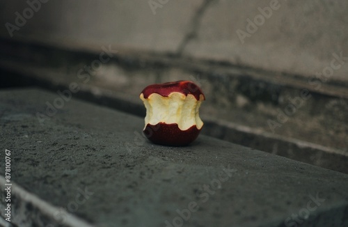 Artistic View of a Bitten Red Apple on a Street Pavement