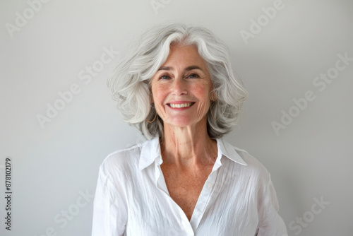 Smiling senior woman with gray hair in a white shirt