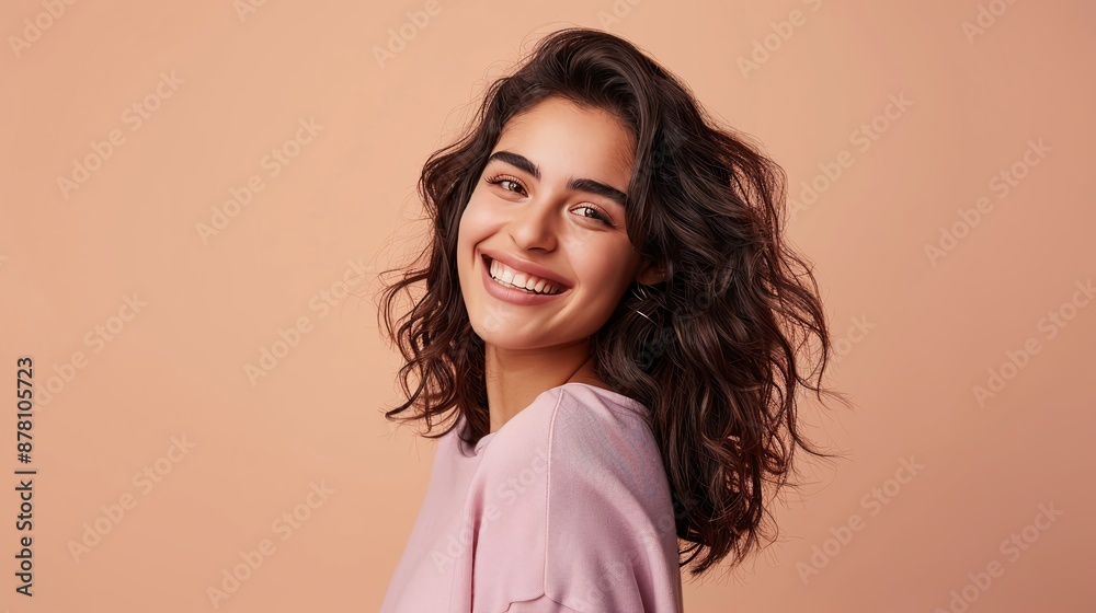 Joyous young woman with beaming smile and soft peach backdrop Joyous young woman with beaming smile and soft peach backdrop