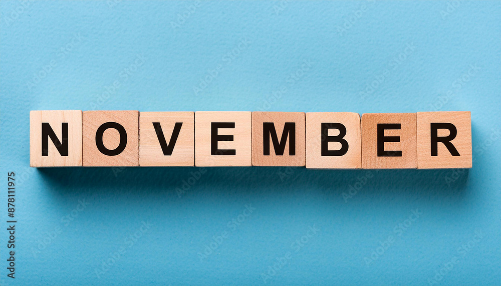 Wooden cubes with text NOVEMBER on cement backdrop. Autumn season. Month of year. Close-up. Wooden cubes with text NOVEMBER on cement backdrop. Autumn season. Month of year. Close-up.