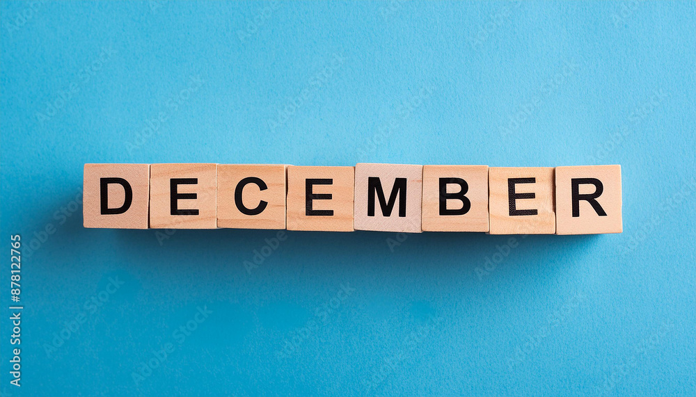 Wooden cubes with text DECEMBER on blue backdrop. Winter season. Month of year. Close-up. Flat lay Wooden cubes with text DECEMBER on blue backdrop. Winter season. Month of year. Close-up. Flat lay