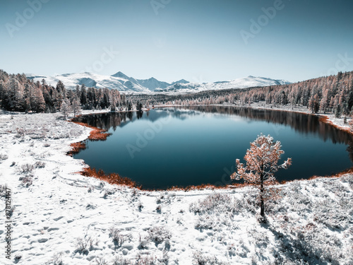 Kidelu lake in Altai mountains, Siberia, Russia. Snow-covered trees and mountains. photo