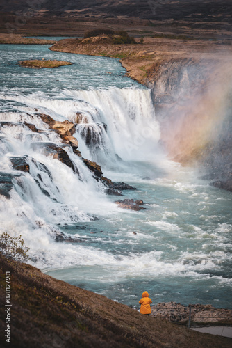 Obraz na płótnie Stunning view of the Gullfoss waterfall with a tourist wearing a yellow jacket. Gullfoss is the most popular waterfall in Iceland and one of its most iconic sights. w salonie