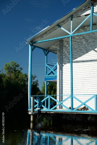 A wooden house stands on the water. Floating wooden structure. House on the lake