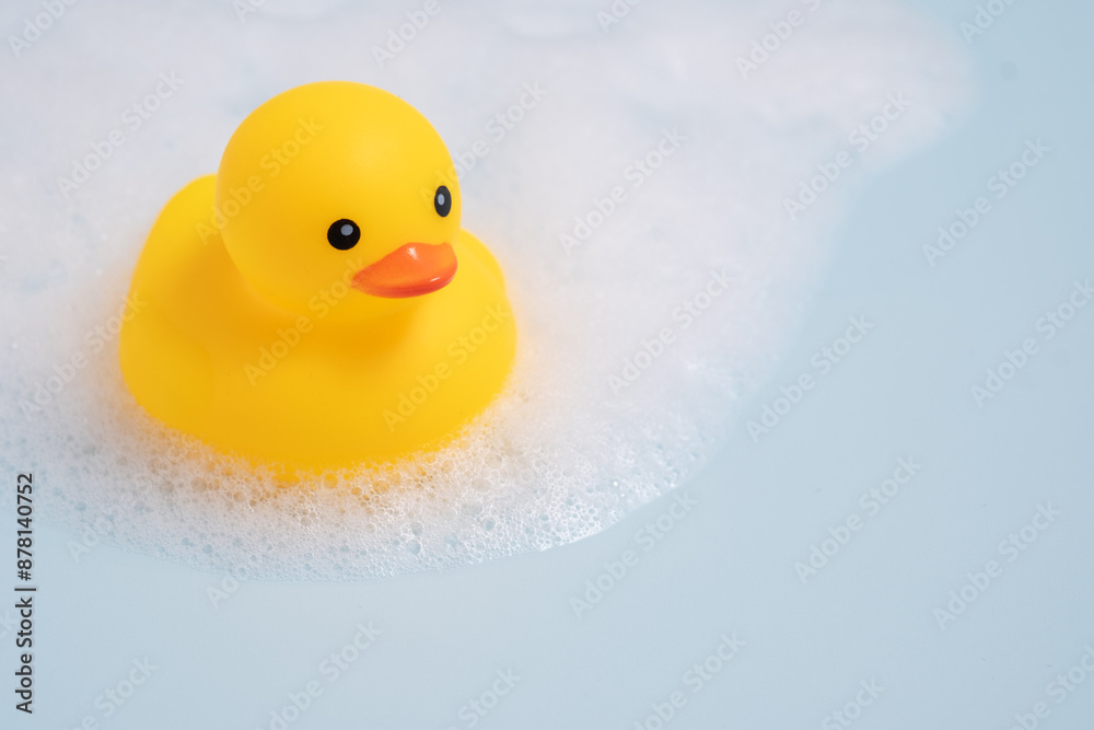 A yellow rubber duck is floating in a bathtub filled with bubbles A yellow rubber duck is floating in a bathtub filled with bubbles