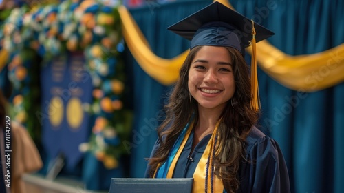 Proud Graduate in Cap and Gown Holding Diploma on Decorated Stage