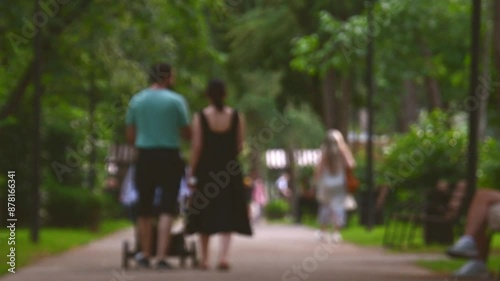 Wallpaper Mural Intentional blurry copy space banner. Mother and father walk together in park push stroll with baby surrounded by summer greenery and pedestrians.City parks and healthy childhood and lifestyle concept Torontodigital.ca