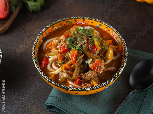 Delicious lagman soup, uzbek lagman soup, Asian cuisine, lagman soup with meat and vegetables. Lagman soup with beef, noodles, sweet peppers, onions and herbs. photo