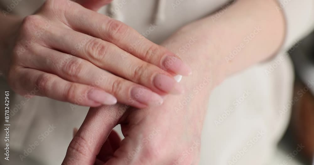 Woman applies cosmetic product on hand skin with finger Woman applies cosmetic product on hand skin with finger