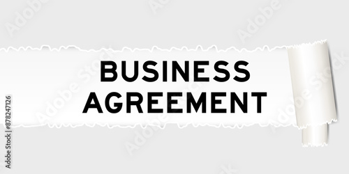 Ripped gray paper background that have word business agreement under torn part