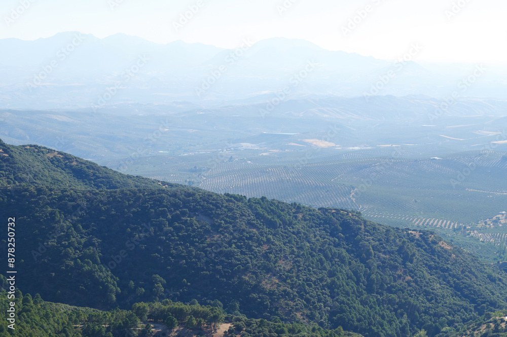 Expansive mountain landscape with lush green valleys and distant mountain ranges under a clear sky Expansive mountain landscape with lush green valleys and distant mountain ranges under a clear sky