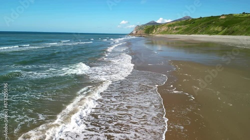 Nefyn beach fast drone low level sweep over waves breaking, beautiful North Wales coastline, UK photo