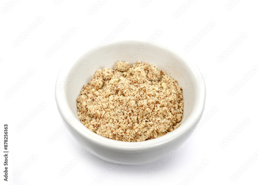 Shelled and ground almond nuts in a bowl. Edible, dried, brown seeds of Prunus dulcis. Ingredient in marzipan, nougat, cookies. Isolated macro food photo close up from above on white background. Shelled and ground almond nuts in a bowl. Edible, dried, brown seeds of Prunus dulcis. Ingredient in marzipan, nougat, cookies. Isolated macro food photo close up from above on white background.
