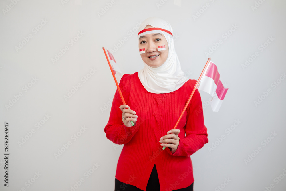 Woman in white hijab wearing red sweater. celebrating Indonesia's independence day. holding the flag with excitement. isolation on white background. Woman in white hijab wearing red sweater. celebrating Indonesia's independence day. holding the flag with excitement. isolation on white background.