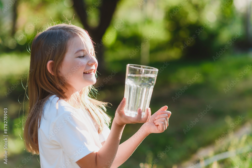 Cute child holding glasses of water in nature Cute child holding glasses of water in nature