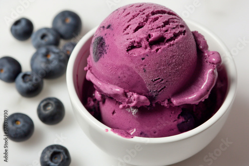 blueberry ice cream in a white bowl on a white background