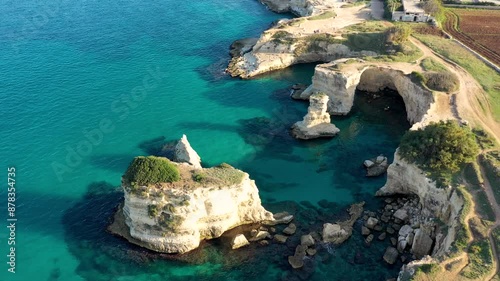 Stunning seascape with cliffs rocky arch and stacks (Faraglioni) at Torre Sant Andrea, Salento coast, Puglia region, Italy. Beautiful cliffs and sea stacks of Sant'Andrea, Salento, Apulia, Italy