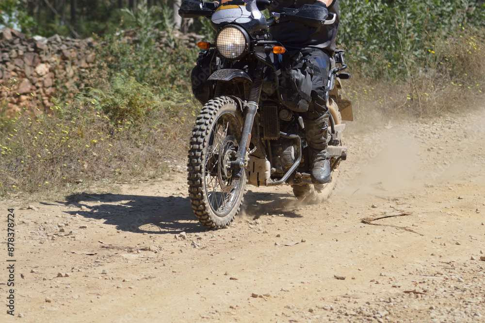 Off-road motorcycle riding on a dry dirt track with stones and lots of dust, movement, motorsport, motocross Off-road motorcycle riding on a dry dirt track with stones and lots of dust, movement, motorsport, motocross