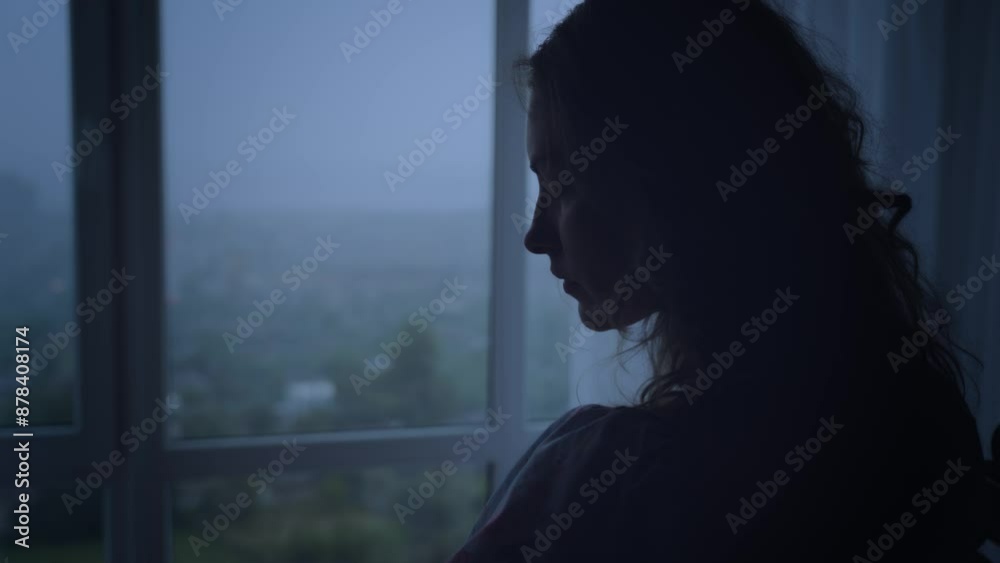 black dark silhouette of young woman crying looking at window rain drops falling rainy weather mood depression sadness loneliness emotion back view. Adult Girl sad tear-stained face. video footage 4k