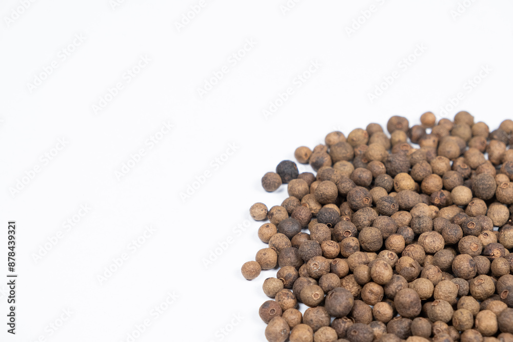 Black peppercorns close-up on white background, copy space for text Black peppercorns close-up on white background, copy space for text