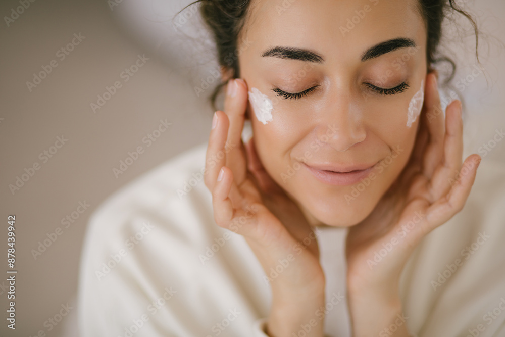 Young woman 30 years old applying face cream on her skin. Young woman 30 years old applying face cream on her skin.