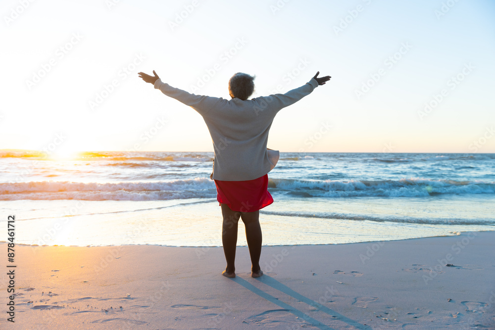 Senior African American woman enjoys a serene beach sunset, with copy space Senior African American woman enjoys a serene beach sunset, with copy space