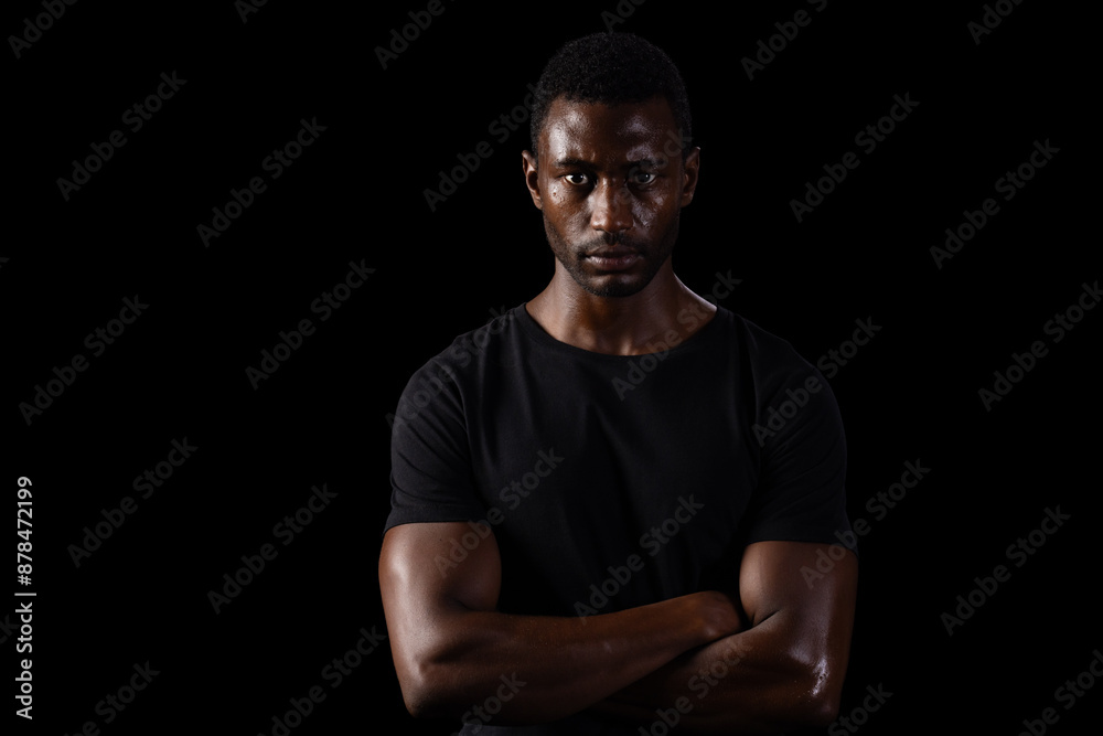 African American man stands confidently against a dark background on black background African American man stands confidently against a dark background on black background