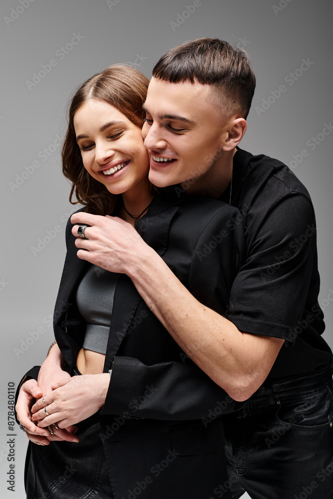 A man and woman passionately embrace each other with a backdrop of a grey studio setting. A man and woman passionately embrace each other with a backdrop of a grey studio setting.
