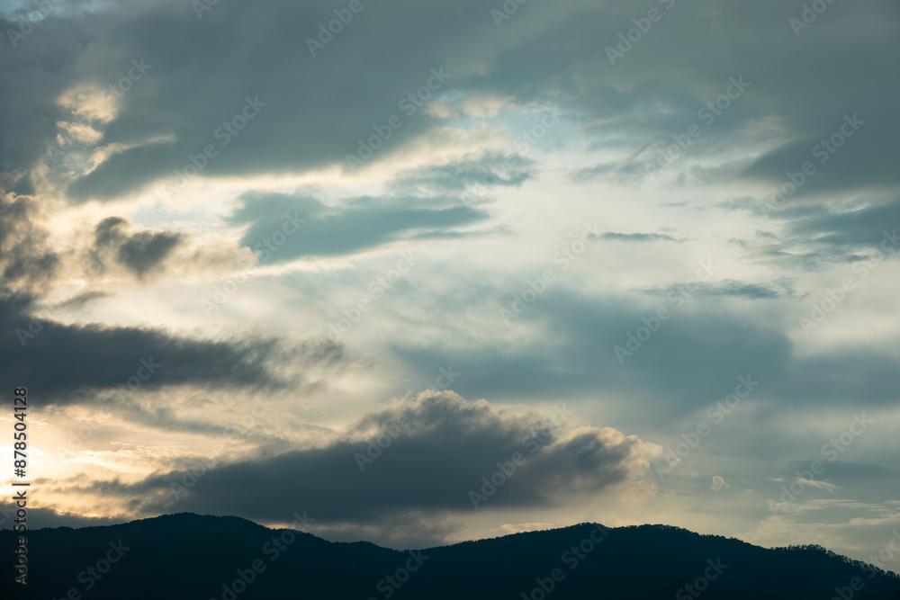 The sky is cloudy and the sun is setting. The clouds are low and the sky is darkening The sky is cloudy and the sun is setting. The clouds are low and the sky is darkening