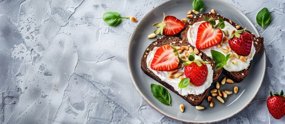 Nutritious breakfast with black bread topped with strawberries, pine nuts, and cheese on a gray concrete background in an authentic lifestyle photograph showcasing a flat lay arrangement with copy Nutritious breakfast with black bread topped with strawberries, pine nuts, and cheese on a gray concrete background in an authentic lifestyle photograph showcasing a flat lay arrangement with copy
