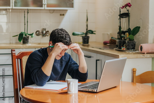 Young man feeling stressed while working from home