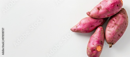 Vegetables, like a sweet potato, displayed on a plain white backdrop, with an empty area for additional imagery. photo