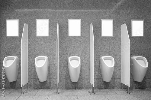Blank advertising posters on the wall by the urinals in toilet