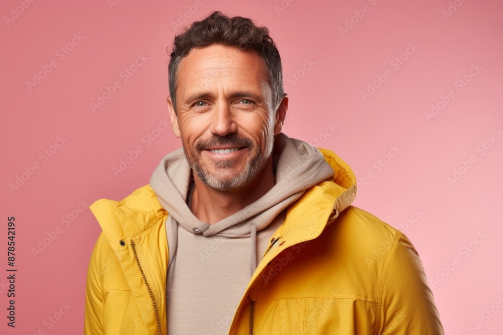 Portrait of a happy man in his 40s dressed in a water-resistant gilet in pastel or soft colors background Portrait of a happy man in his 40s dressed in a water-resistant gilet in pastel or soft colors background