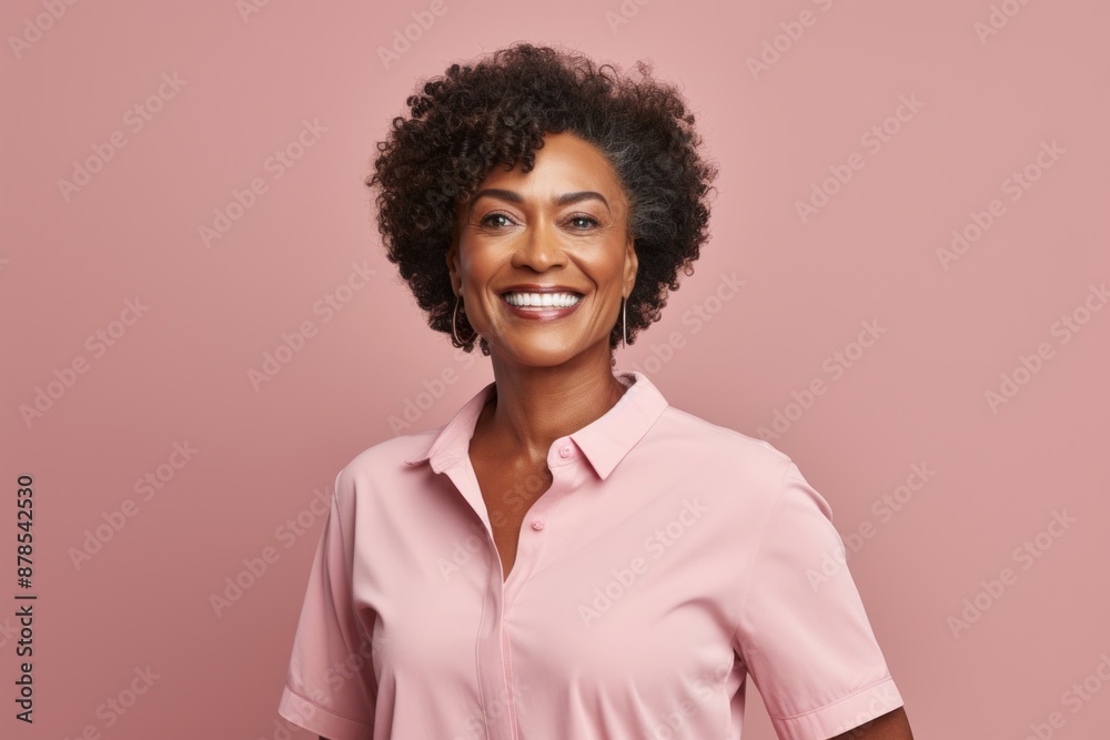 Portrait of a content afro-american woman in her 50s donning a classy polo shirt while standing against pastel or soft colors background Portrait of a content afro-american woman in her 50s donning a classy polo shirt while standing against pastel or soft colors background