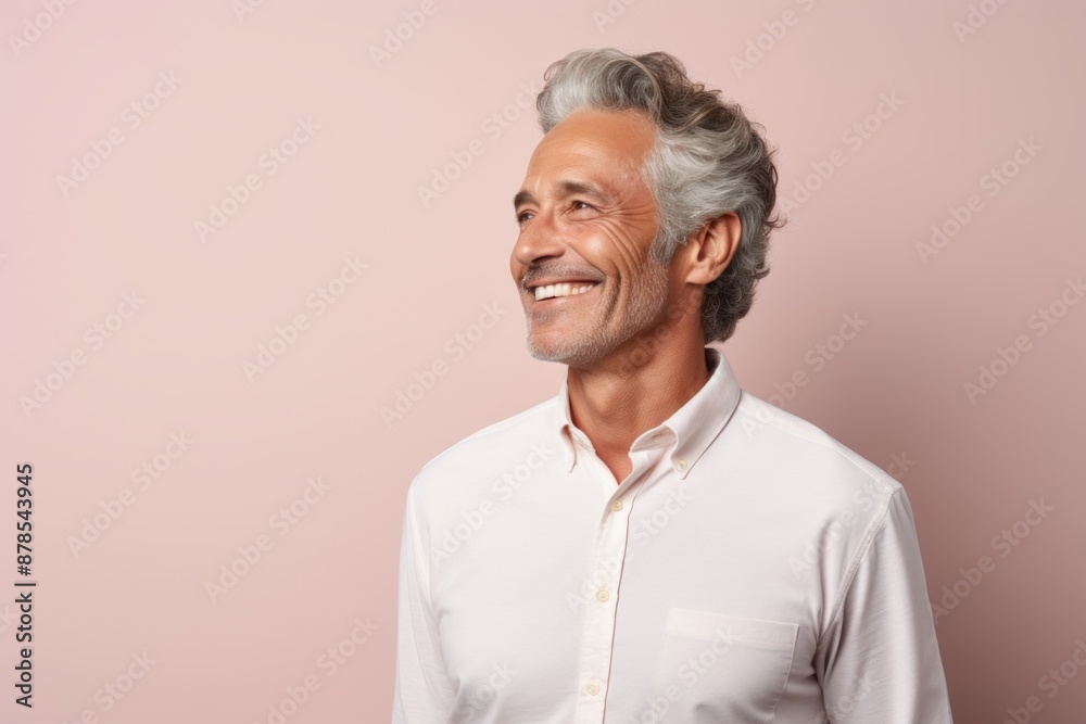Portrait of a joyful man in his 50s wearing a simple cotton shirt isolated in pastel or soft colors background Portrait of a joyful man in his 50s wearing a simple cotton shirt isolated in pastel or soft colors background