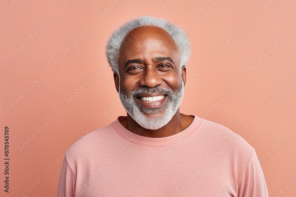 Portrait of a smiling afro-american man in his 60s sporting a long-sleeved thermal undershirt over pastel or soft colors background