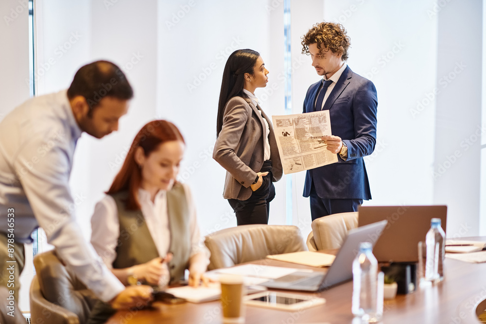 Multiracial business professionals collaborating around conference table. Multiracial business professionals collaborating around conference table.