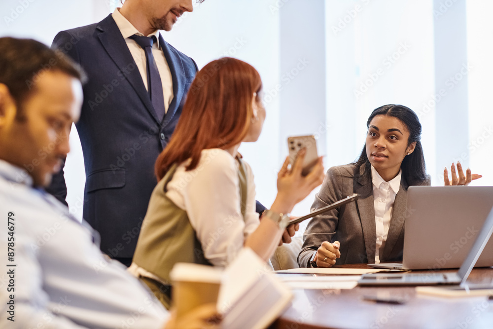 Multicultural business team brainstorming around conference table. Multicultural business team brainstorming around conference table.