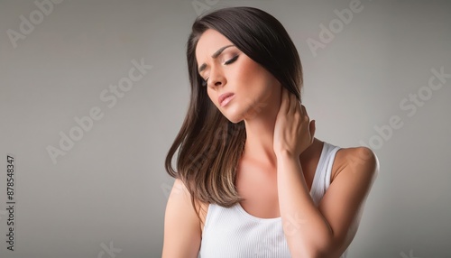 A woman with long, dark hair, showing a pained expression, holds her neck with her hand, indicating discomfort or pain