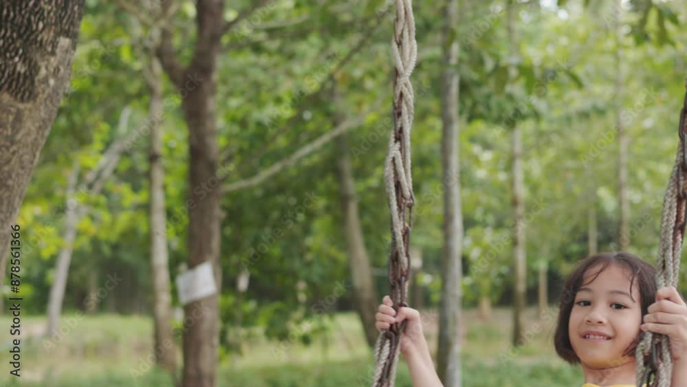 Adorable asian young girl swings joyfully in an outdoor surrounded by trees. It shows the essence of childhood play, happiness, and adventure, highlighting the carefree spirit and serenity of nature. Adorable asian young girl swings joyfully in an outdoor surrounded by trees. It shows the essence of childhood play, happiness, and adventure, highlighting the carefree spirit and serenity of nature.
