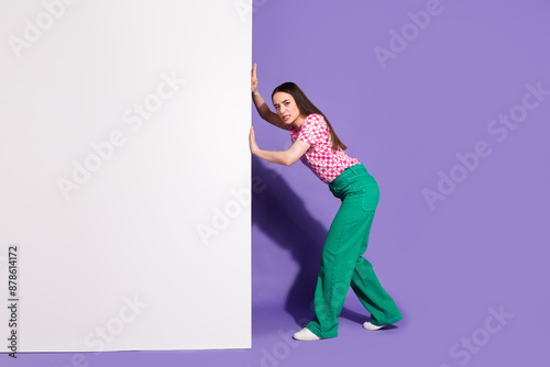Full size photo of pretty young girl push stressed white wall empty space wear trendy pink outfit isolated on purple color background